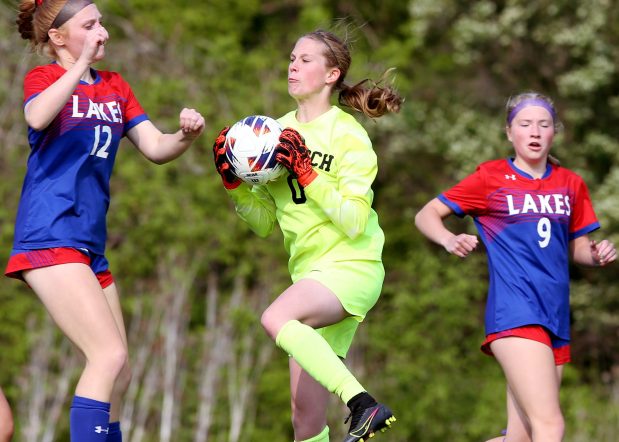 Antioch goal keeper, Maddie Barrett (green), grabbing a ball as Lakes' Emily Mylniec (12) and Jodie Bristol (9), pressure, during the Class 2A Lakes Regional semifinal, on Wednesday, May 17, 2023, in Lake Villa. (Mark Ukena for Lake County News-Sun)