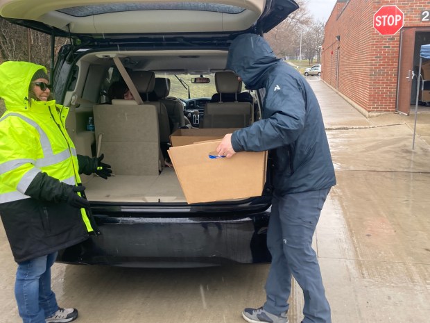 Volunteers put a box of meals for a week in a vehicle Monday at the Waukegan High School Brookside Campus. (Steve Sadin/Lake County News-Sun)