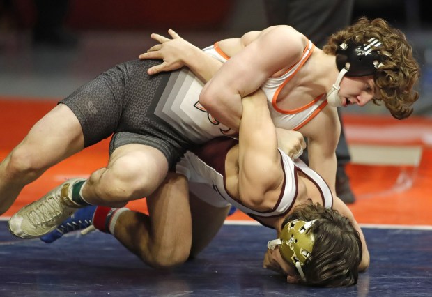 St. Charles East's Ben Davino, top, and Loyola's Massey Odiotti battle in the 120-pound state championship match in Class 3A at the State Farm Center in Champaign on Saturday, Feb. 19, 2022.