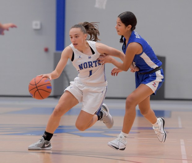 St. Charles North's Laney Stark (1) drives past Larkin's Yesenia Escobar (4) against Larkin during a game in the Mark Einwich Rockets Kick-Off Tournament at Burlington Central on Monday, Nov. 13, 2023.