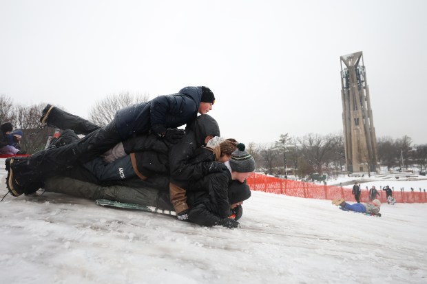 Sam Hayes, 14, Calum Baham, 15, Julian Thomas, 15, Blake Highhantes, 15 and Jack Libeo, 14, pile onto each other prior to sledding down Rotary Park Sled Hill in Naperville as a winter storm hits the Chicago area with near-blizzard conditions on Friday, Jan. 12, 2023.