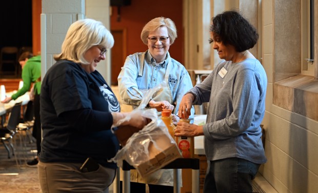 From left, volunteers Traci Parks of Northbrook, Liz Ganitopoulos of Northbrook and Deb Valkenaar of Prospect Heights prepare beverage and condiments in the dining hall at the 68th annual Pancake Festival on Saturday, March 2, 2024 at The Village Church in Northbrook. (Karie Angell Luc/Pioneer Press)