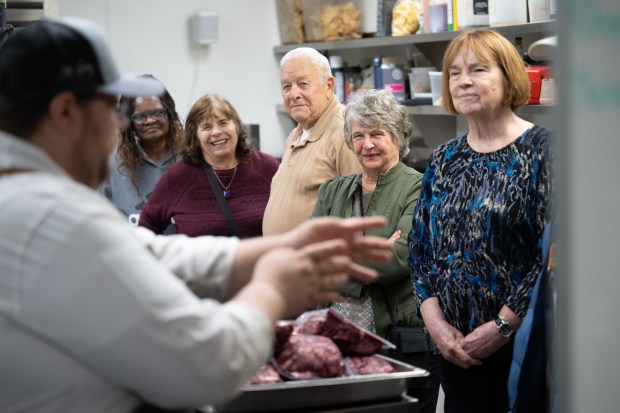 Members of the tourism industry watch as Provecho latin Provisions sous chef Jarett Nelson leads them on a tour of the restaurant's kitchen during a stop on the Heartland Familiarization tour in Crown Point on Tuesday, March 5, 2024. (Kyle Telechan/for the Post-Tribune)