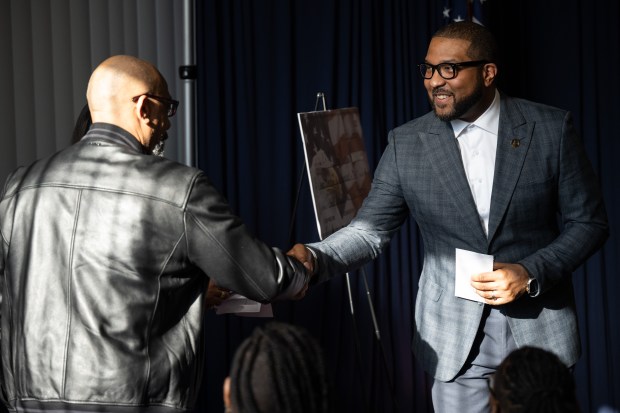 Gary Mayor Eddie Melton, on right, shakes hands with CGA Power Washing owner Emanuel Christmas after presenting him with a $7500 American Rescue Plan Act grant check for his business during a meet and greet and check presentation event in Gary on Wednesday, March 6, 2024. (Kyle Telechan/for the Post-Tribune)