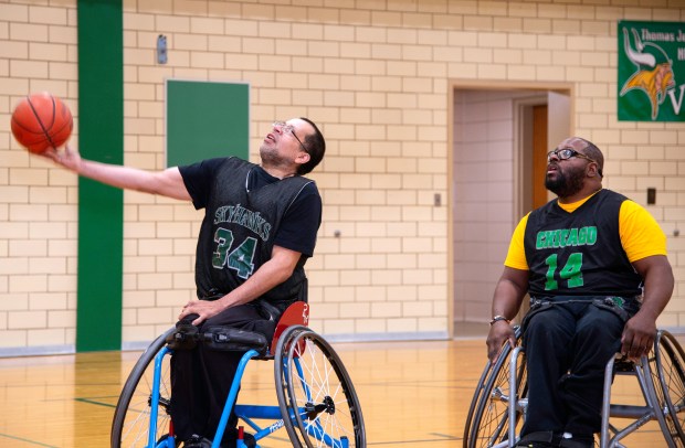 Ramon Medina of the Chicago Skyhawks wheelchair basketball team, left, and teammate Ivory Harris shoot baskets during an author reading and wheelchair basketball demonstration on Saturday, March 16, 2024 at Thomas Jefferson Middle School in Valparaiso. (Michael Gard/for the Post-Tribune)