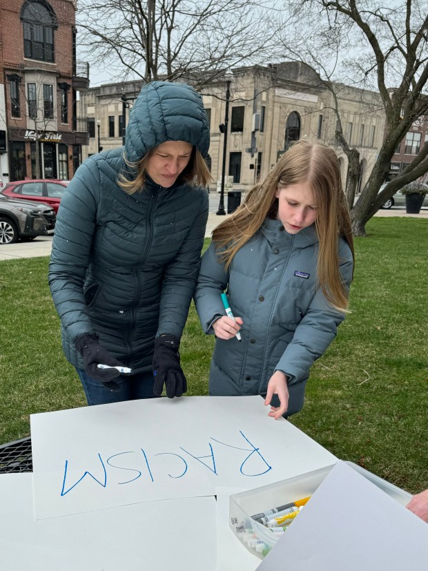 Rebecca Puffer, of Valparaiso, and daughter, Kate, make a sign to participate in the anti-racism rally held on Sunday, March 17, 2024, on the courthouse square in downtown Valparaiso. (Deena Lawley-Dixon/for Post-Tribune)