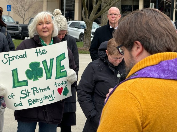 Pat Wisniewski, of Valparaiso, listens to First Christian Church Pastor Tim Trussell-Smith give a blessing at the anti-racism rally in downtown Valparaiso on Sunday, March 17, 2024. (Deena Lawley-Dixon/for Post-Tribune)