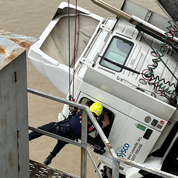 This photo provided by Louisville Division of Fire, Louisville Fire Dept., Louisville firefighter Bryce Carden rescue the driver of semitruck that is dangling off the Clark Memorial Bridge over the Ohio River on Friday, March 1, 2024 in Louisville, Ky. The driver was pulled to safety by firefighters following the three-vehicle crash on the bridge connecting Louisville, Kentucky to southern Indiana. (Louisville Division of Fire via AP)