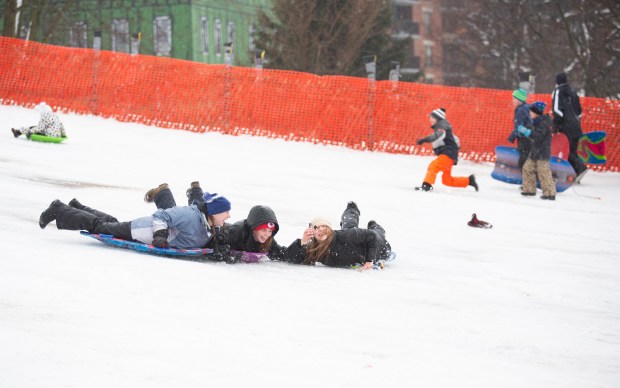 While adults were digging out from the snow that moved through Naperville overnight Friday, kids took to the sledding hill at Rotary Park. Riley Howard, 17, left, Morgan Maher, 18, center, and Michelle Jurec, 18, right, took advantage of the break in storms to enjoy the winter conditions.