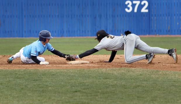 Reavis Jose Gonzalez dives back to second and tagged out by Marian Catholic's Jonah Weathers during the baseball game in Burbank Tuesday, March 26, 2024. (James C. Svehla/for the Daily Southtown)