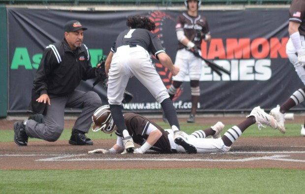 Mount Carmel's Kevin Zanin slides home under the tag of Bremen pitcher Armando Aguilar in the second inning of a nonconference game at Ozinga Field in Crestwood on Wednesday, March 13, 2024. (Jeff Vorva / Daily Southtown)