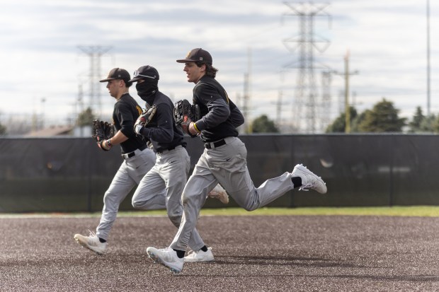 St. Laurence's Evan Les runs toward his coaches with his teammates during practice in Burbank on Monday, March 18, 2024. (Troy Stolt/for the Daily Southtown)