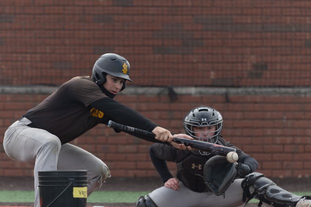 St. Laurence's Cory Les hits a bunt during practice in Burbank on Monday, March 18, 2024. (Troy Stolt/for the Daily Southtown)