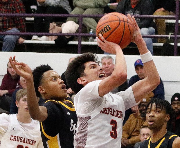 Brother Rice's Marcos Gonzales (center) lays up a basket as Adam Shorter of Marian Catholic (left) can only watch during the Class 3A Thornton Sectional basketball semifinals In Harvey, Il., on Wednesday, February 28, 2024. (John Smierciak for the Daily Southtown)