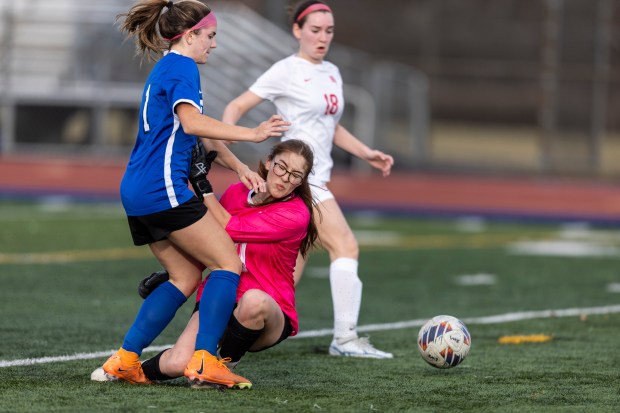 Lincoln-Way East's Cami Butler collides with Homewood-Flossmoor's goalie Cristina Ramirez in Frankfort on Tuesday, March 12, 2024. (Vincent D. Johnson/for the Daily Southtown)