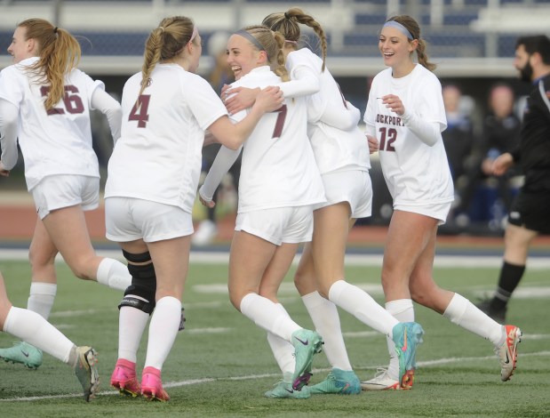 Lockport's Emma Czech (7) receives congratulations from her teammates after scoring the first goal for the Porters against Lincoln-Way East during the Windy City Ram Classic Championship game Thursday, March 21, 2024 in Burbank, IL. (Steve Johnston/Daily Southtown)