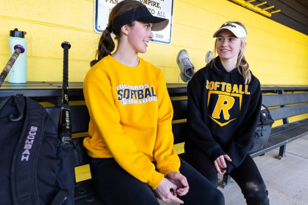 Richard's Violet McIntyre, left, and Olivia Conglianese talk in the dugout during practice in Oak Lawn on Wednesday, March 27, 2024. (Vincent D. Johnson/for the Daily Southtown)