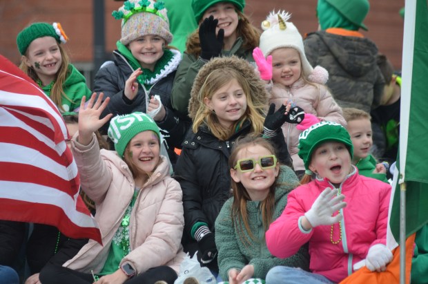 Students from St. Christina School smile and wave from their float Sunday at the South Side Irish Parade. (Jeff Vorva/for Daily Southtown)