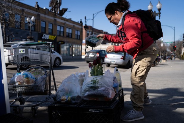 Vincenta Buitrago leaves Nourishing Hope-Sheridan Market with her food items on Monday, Feb. 26, 2024. Food pantries in Chicago are struggling to meet demand with the influx of migrants in the city. (E. Jason Wambsgans/Chicago Tribune)