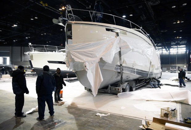 Workers pull the protective wrapping off a Carver C52 Coupe yacht as preparations continue for the Chicago Boat, RV & Sail Show at McCormick Place in Chicago on Jan. 4, 2018. (Terrence Antonio James/Chicago Tribune)