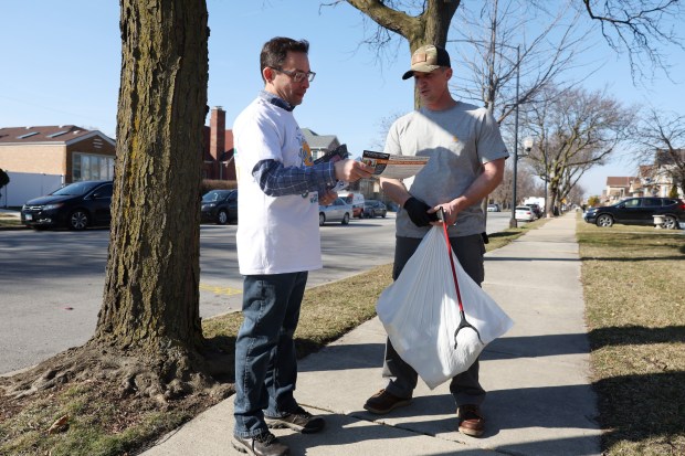 Ald. Raymond Lopez, 15th, candidate for U.S. Congress in the 4th District, left, talks with prospective voter Kevin Verner while canvassing in the 5600 block of South Austin Avenue on March 2, 2024, in Chicago. (John J. Kim/Chicago Tribune)