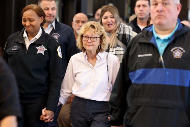 Surrounded by police officers, family and supporters, Elizabeth French, mother of slain police Officer Ella French, arrives for the opening statements in the murder trial on Feb. 27, 2024, at the Leighton Criminal Court Building in Chicago. (Antonio Perez/Chicago Tribune)