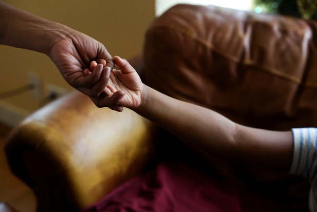 Kiana Kelly holds the hand of her daughter Ke'Asia, after Ke'Asia told her mother that she can take care of her when she grows up and that her mother has to be strong, Jan. 3, 2024. (Eileen T. Meslar/Chicago Tribune)