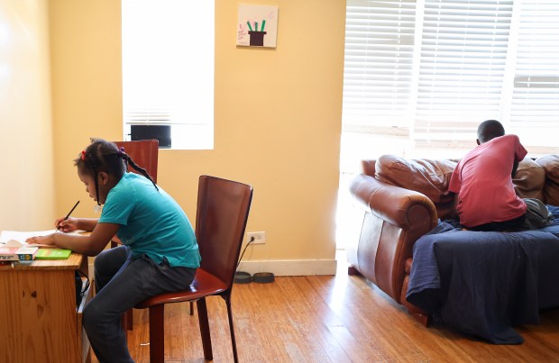 Ke'Asia Kelly draws with her new colored pencils and sketchbook as her brother Hezekiah looks out the window of their Highland Park home on Jan. 17, 2024. (Eileen T. Meslar/Chicago Tribune)