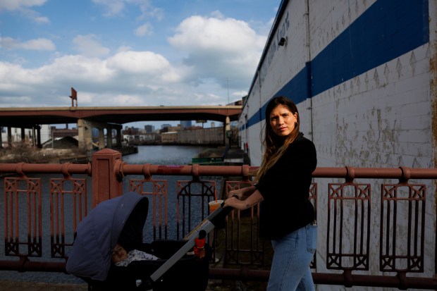 Anghely Cepeda, 25, holds a stroller with her 1-year-old Samuel Cepeda while posing for a portrait near a migrant shelter on the Lower West Side on Monday, March 4, 2024, in Chicago. Cepeda, who's from Venezuela, has been staying at the shelter since December. (Armando L. Sanchez/Chicago Tribune)