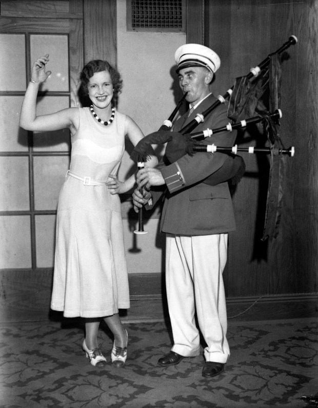 Eileen O'Connor does "an old-fashioned Irish jig to the strains of the bagpipe played by Tommie Ryan, member of the Shannon Rovers Irish Pipe Band, at the festival of the Chicago Irish-American Societies at the Knights of Columbus Auditorium," circa 1931. (Chicago Herald and Examiner