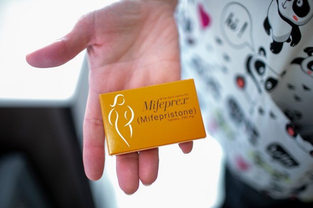 Brenda Morgan, Training and Education specialist for Whole Woman's Health of South Bend, Indiana, holds Mifepristone, a progesterone blocker that can end a pregnancy that is less than 10 weeks along, July 19, 2019. (Camille Fine/Chicago Tribune)