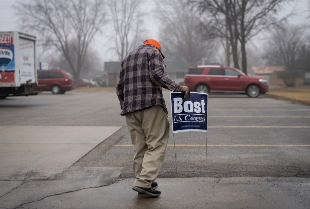 A farmer carries a sign supporting U.S. Rep. Mike Bost in Effingham on Jan. 24, 2024. (E. Jason Wambsgans/Chicago Tribune)