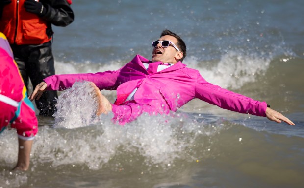 Costumed participants take a dip in Lake Michigan on a warm morning during the 24th Annual Chicago Polar Plunge, Sunday, March 3, 2024, at North Avenue Beach. (Brian Cassella/Chicago Tribune)