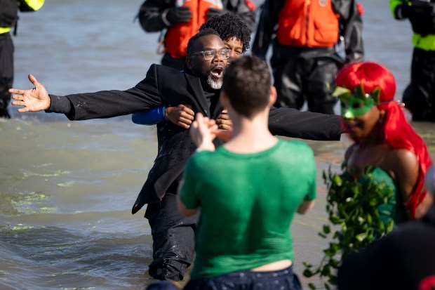 Mayor Brandon Johnson and his son Owen take a dip in Lake Michigan on a warm morning during the 24th Annual Chicago Polar Plunge, Sunday, March 3, 2024, at North Avenue Beach. (Brian Cassella/Chicago Tribune)