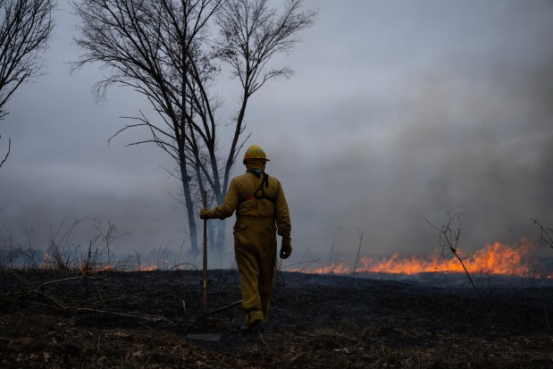 A restoration technician watches a prescribed burn at Nachusa Grasslands on March 7, 2024. (E. Jason Wambsgans/Chicago Tribune)