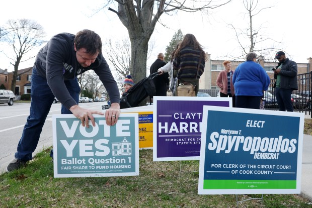 Matt Ginsberg-Jaeckle (cq) secures a campaign lawn sign about the Bring Chicago Home real estate transfer tax referendum after early voting at a polling place in the Chicago Public Library Northtown Branch, 6800 N. Western Ave., Saturday, March 16, 2024, in Chicago. (John J. Kim/Chicago Tribune)