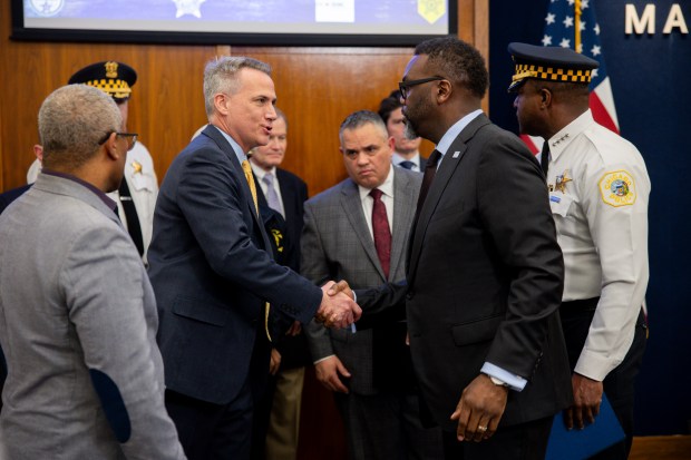 Jeff Burnside, second from left, the Secret Service coordinator for the convention, shakes hands with Mayor Brandon Johnson during a news conference March 6, 2024, at Chicago City Hall about safety and security issues at the upcoming Democratic National Convention. (Vincent Alban/Chicago Tribune)