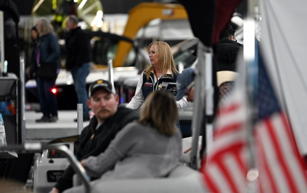 Top, Jenny Copenharve of Spring Grove, with Munson Ski & Marine of Volo, Round Lake, McHenry and Fontana, Wisconsin, waits to speak with customers at the Northern Illinois Boat Show on opening day, Feb. 29, 2024 at the Lake County Fairgrounds (1060 E. Peterson Road) in Grayslake. (Karie Angell Luc/Lake County News-Sun)