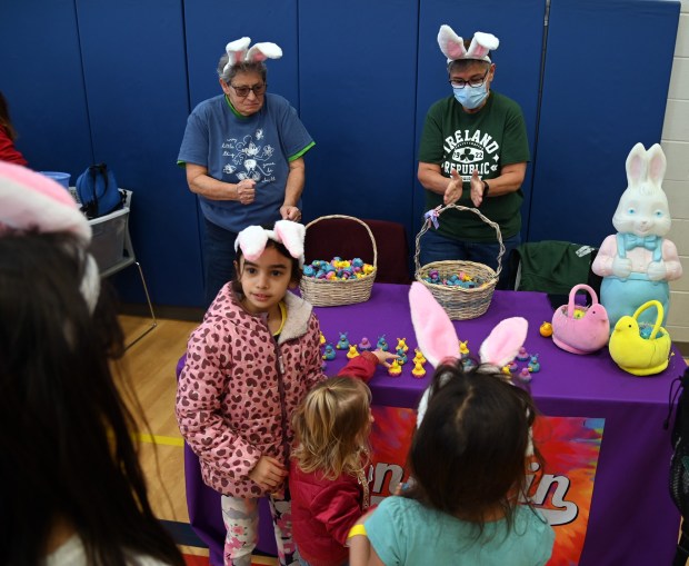 Top, from left to right, Chris Woodard and Susan Goedke of Mundelein, wearing pink and white bunny ear headbands, staff a table on behalf of the Mundelein LGBT Alliance and Allies. Kiddies could choose spring mini rubber duckies in bright colors with bunny ears at the Cottontail Trail event on March 16, 2024 at the Dunbar Recreation Center at Community Park in Mundelein. (Karie Angell Luc/Lake County News-Sun).