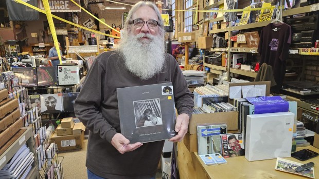 Aurora resident Steve Warrenfeltz, owner of Kiss the Sky record store in Batavia, shows off the new Taylor Swift vinyl album that was produced exclusively for 2023 Record Store Day. (David Sharos/The Beacon-News)