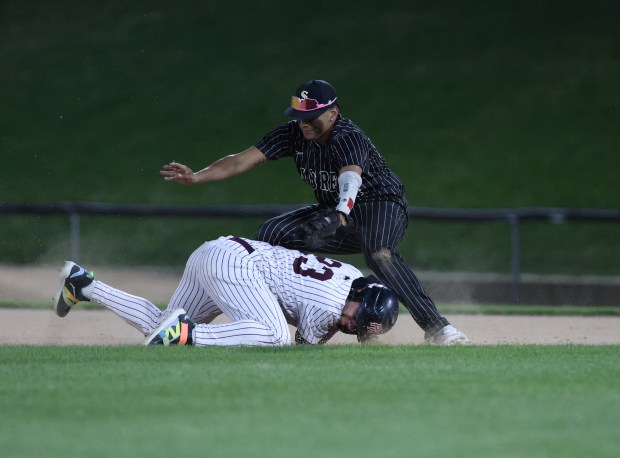 Elgin catcher Juan Carlos Betancourt (23) is tagged out by Streamwood first baseman Isaiah Shafi (27) after tripping while running to second base during a game at Wintrust Field in Schaumburg on Tuesday, April 9, 2024. (Trent Sprague/Chicago Tribune)