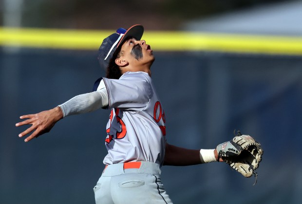 Oswego's Kamrin Jenkins (23) chases down a fly ball buffeted by the wind for the final out in the seventh inning during an Southwest Prairie Conference game against West Aurora in Aurora on Thursday, April 18, 2024. Oswego won, 5-3.H. Rick Bamman / For the Beacon-News