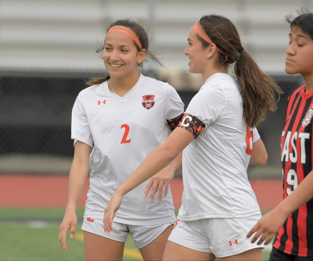 Sisters Grace Braun (2) and Natalie Braun (8) celebrate family effort goal against East Aurora on Wednesday, April 10, 2024. (Mark Black / for the Beacon-News)