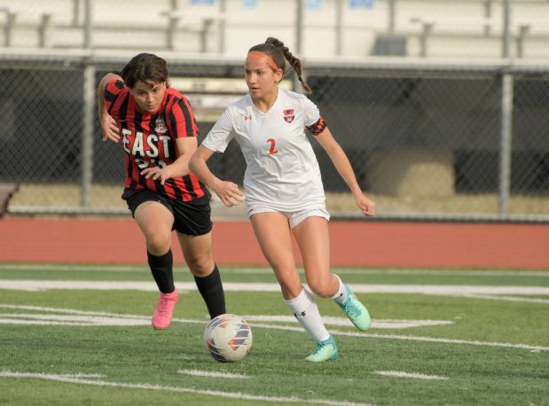 Oswego's Grace Braun (2) keeps the ball from East Aurora's Noreidy Ruiz (23) during a game in Aurora on Wednesday, April 10, 2024. (Mark Black / for the Beacon-News)