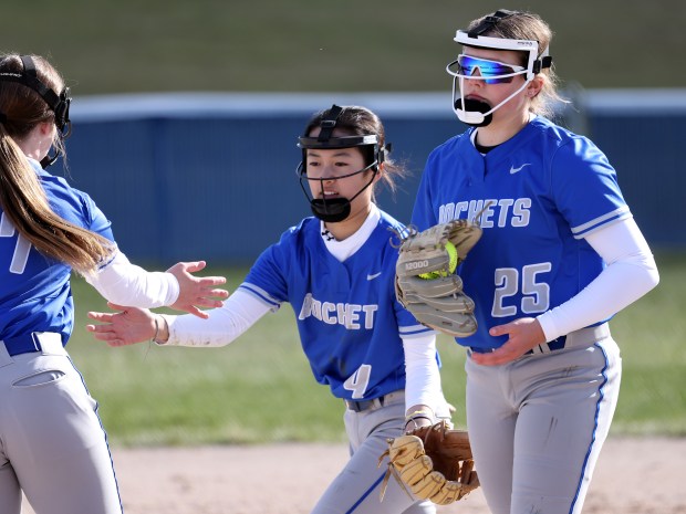 Burlington Central's Kelsey Covey (7), Mei Shirokawa (4) slap hands before Burlington Central's Emmerson Falk (25) pitches against Geneva during a non-conference game in Burlington on Friday, April 5, 2024. Burlington Central won 14-5 in five innings.H. Rick Bamman / For the Beacon-News