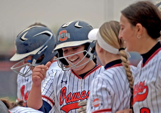 Oswego's Aubriella Garza is mobbed by teammates after crossing the plate for her three run homer. Oswego defeated Oswego East in softball, 9-8, Thursday, April 18, 2024, in Oswego, Illinois. (Jon Langham/for the Beacon-News)