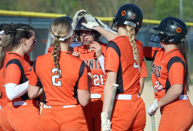 St. Charles East's Hayden Sujack is greeted at by teammates after her homerun during the softball game against Geneva Tuesday, April 23, 2024, in Geneva. (James C. Svehla/for the Beacon News)