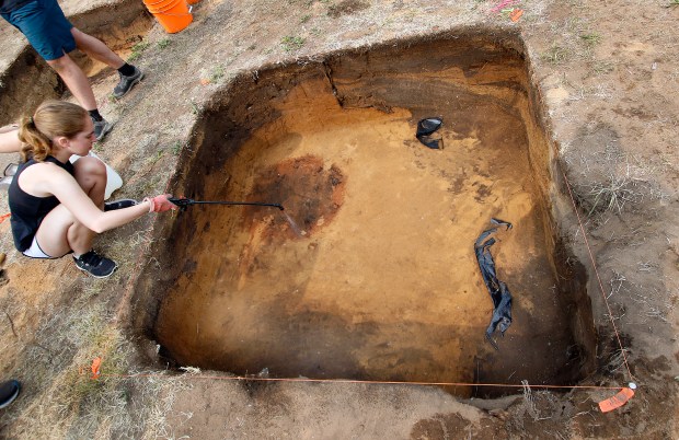 Sophie Chorek of Fairfield, Connecticut, sprays water into an excavated pit to darken the color. A roasting food pit can be seen in the left top corner during the last day of a two-week archaeological dig at the Collier Lodge site in Kouts. Volunteers and Notre Dame personnel work at the site on Thursday, June 15, 2023. (John Smierciak/Post-Tribune)