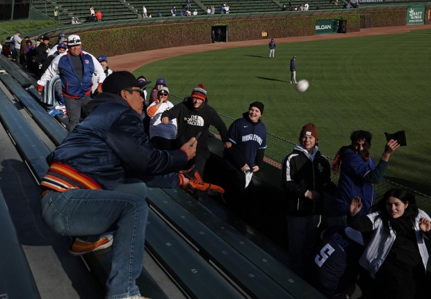 Fans in the left-field bleachers watch Nguyen Le, of Houston, catch a home run ball during batting practice for a game between the Astros and Cubs at Wrigley Field on April 24, 2024, in Chicago. (John J. Kim/Chicago Tribune)