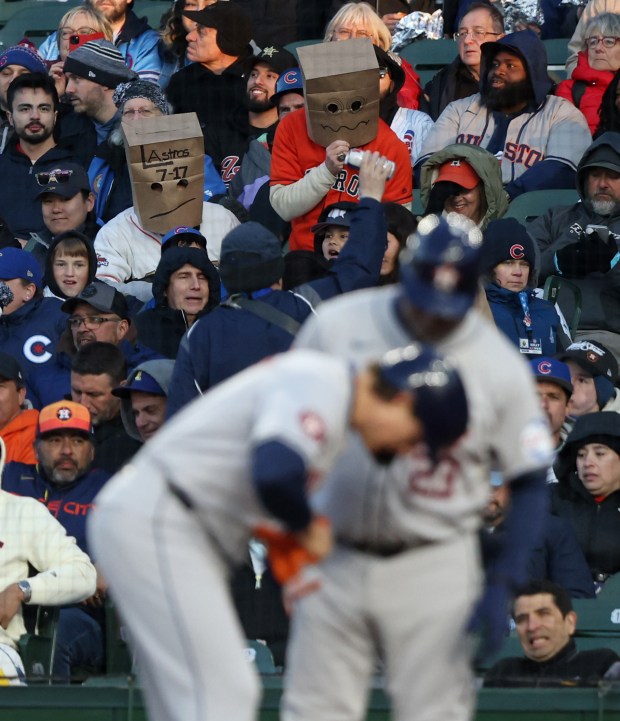 Two Astros fans wear brown paper bags in apparent embarrassment of the team's record and standings in the A.L. West, in the third inning against the Cubs at Wrigley Field on April 24, 2024, in Chicago. (John J. Kim/Chicago Tribune)